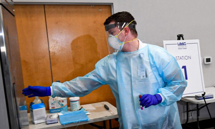 LAS VEGAS, NEVADA - NOVEMBER 30:  University Medical Center of Southern Nevada supervisor Isaac Nielson puts a coronavirus (COVID-19) specimen sampling tube into a refrigerator during a preview of a testing site at the Stan Fulton - International Gaming Institute Building at UNLV on November 30, 2020 in Las Vegas, Nevada. The state set its two highest single-day COVID-19 case records and surpassed 150,000 total cases last week. Nevada has seen a sharp upward climb in the test positivity rate since the end of October, which has now grown to more than 17 percent. Clark County and UMC are operating the new site, which has separate areas for people who arrive with and without symptoms of COVID-19, in partnership with the Nevada National Guard and University Police Services.  (Photo by Ethan Miller/Getty Images)