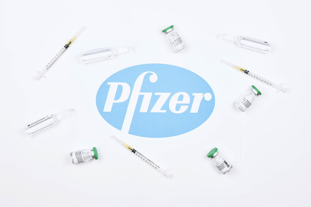 vaccine-doses-and-syringe-for-injection-around-the-pfizer-logotype